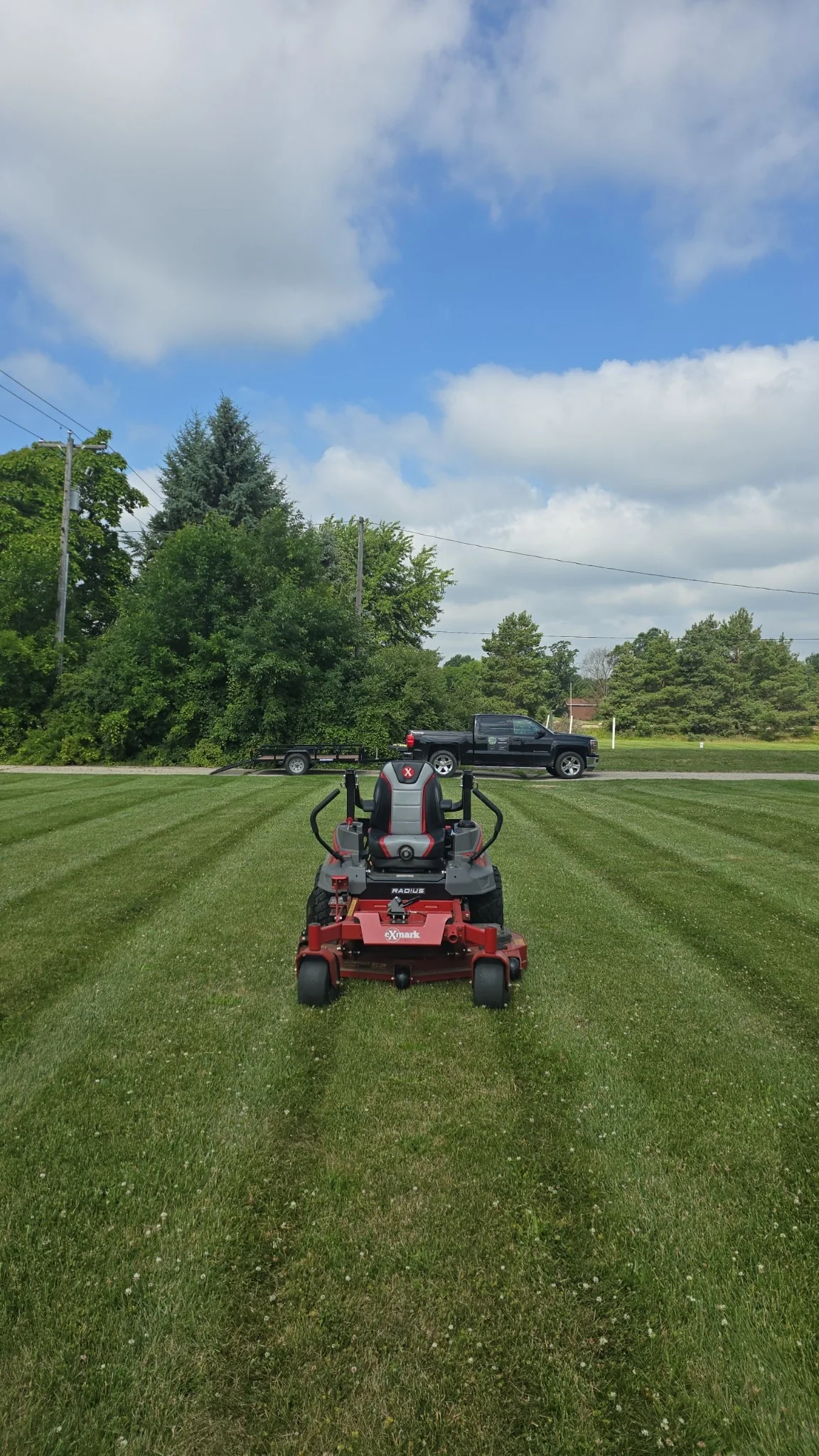 Exmark mower and work truck on a finished lawn