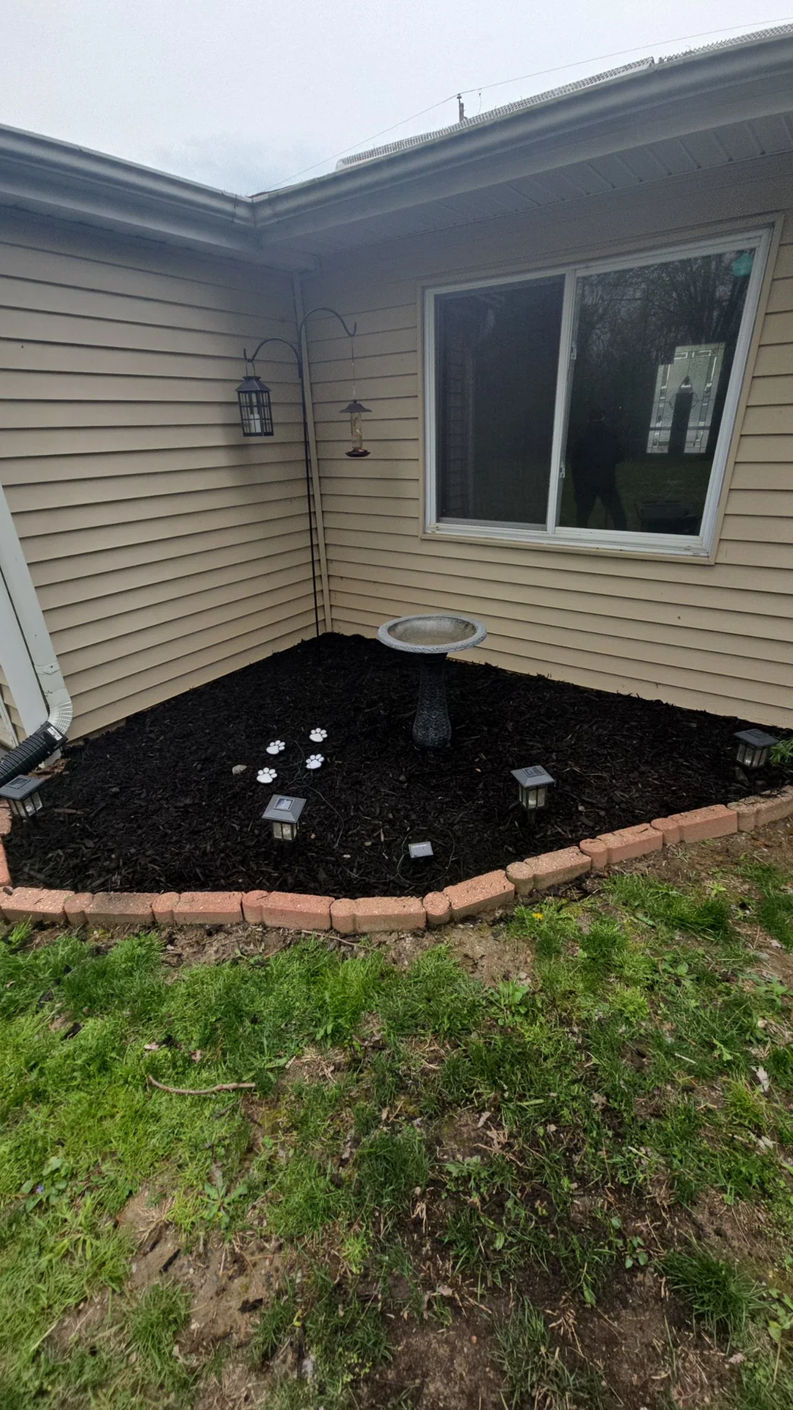 Fresh black mulch installation around a home